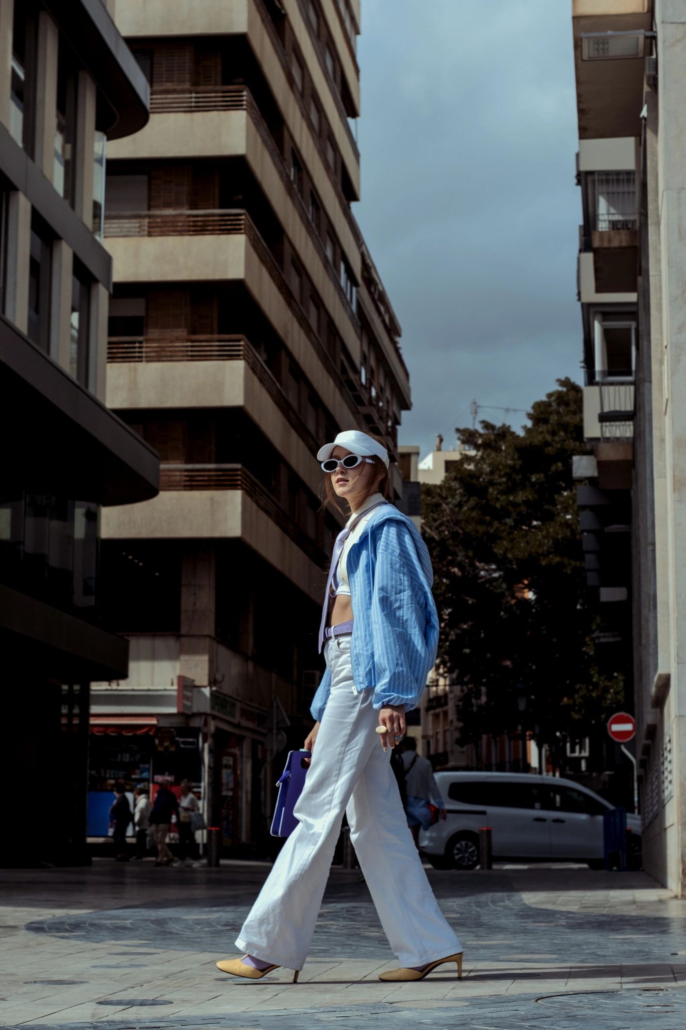 Street style look with a light blue jacket and white pants
